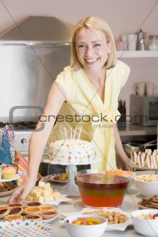 Woman at party getting tart from food table smiling