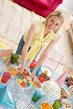 Woman at party setting out food and smiling