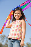 Young girl with kite outdoors smiling
