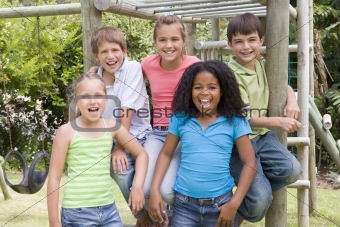 Five young friends at a playground smiling