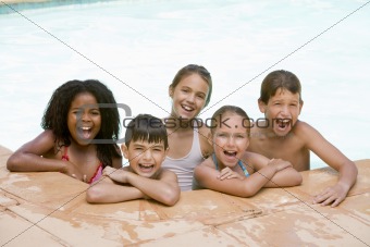 Five young friends in swimming pool smiling