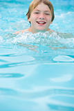 Young boy in swimming pool smiling