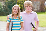 Young couple with rackets on tennis court smiling