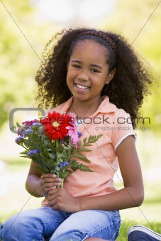 Young girl holding flowers and smiling