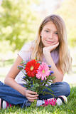 Young girl holding flowers and smiling