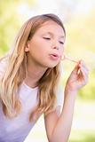 Young girl blowing bubbles outdoors