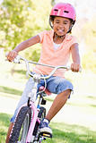 Young girl on bicycle outdoors smiling