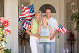 Family at front door on fourth of July with flags and cookies sm