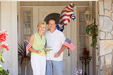 Couple at front door on fourth of July with flags and cookies sm