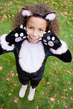 Young girl outdoors in cat costume on Halloween