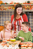 Mother and two children at Halloween making treats and smiling