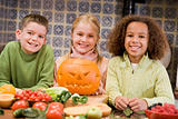 Three young friends on Halloween with jack o lantern and food sm