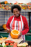 Woman on Halloween making jack o lantern smiling