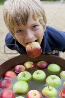 Young boy bobbing for apples