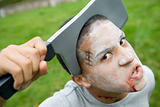 Young boy with scary Halloween make up and plastic knife through