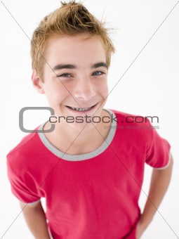 Teenage boy with hands in pockets smiling