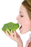 Teenage girl eating broccoli