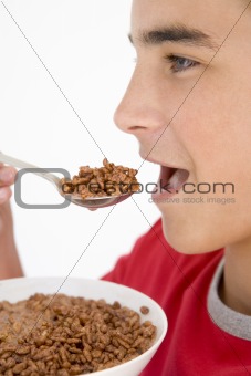 Boy eating chocolate puff cereal