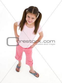 Young girl standing with hands on hips smiling