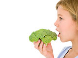 Young girl eating broccoli