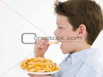 Young boy eating French fries