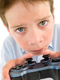 Young boy using videogame controller and concentrating