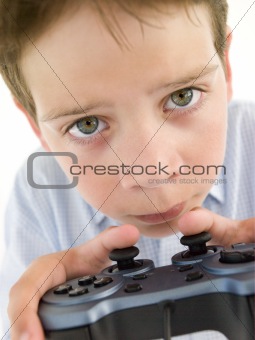 Young boy using videogame controller and concentrating