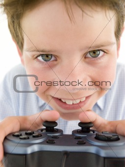 Young boy using videogame controller smiling