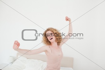 Charming blonde female stretching in her bedroom