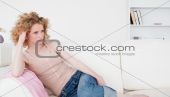 Attractive blonde woman relaxing while sitting on a sofa