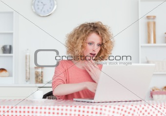 Attractive blonde female relaxing with her laptop while sitting 