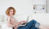 Good looking blonde woman relaxing with her laptop while sitting