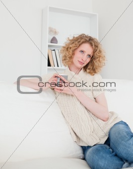 Attractive blonde female enjoying a cup of coffee while sitting 