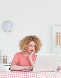 Charming blonde female relaxing with her laptop while sitting in