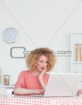 Charming blonde female relaxing with her laptop while sitting in