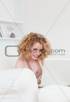 Charming blonde female relaxing with her laptop while sitting on