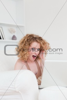 Attractive enthusiastic blonde female relaxing with her laptop w