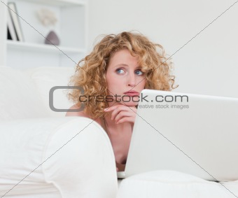 Lovely anxious female relaxing with her laptop while sitting on 