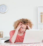 Lovely blonde female being angry while relaxing with her laptop 