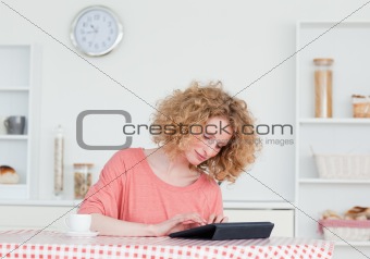 Pretty blonde woman relaxing with her tablet while sitting in th