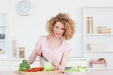 Pretty blonde woman cooking some vegetables in the kitchen