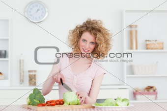 Pretty blonde woman cooking some vegetables in the kitchen