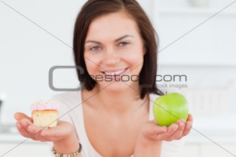 Close up of a cute woman with an apple and a piece of cake