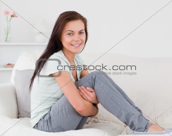 Close up of a brunette posing on her sofa