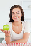Charming brunette showing an apple