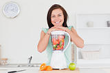 Smiling cute woman posing with a blender