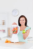 Cute woman with a blender and an apple