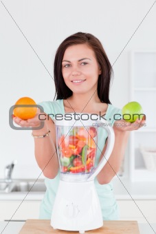 Happy woman with a blender and fruits