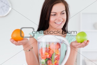 Charming woman with a blender and fruits