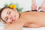 Charming woman having a hot stone massage 